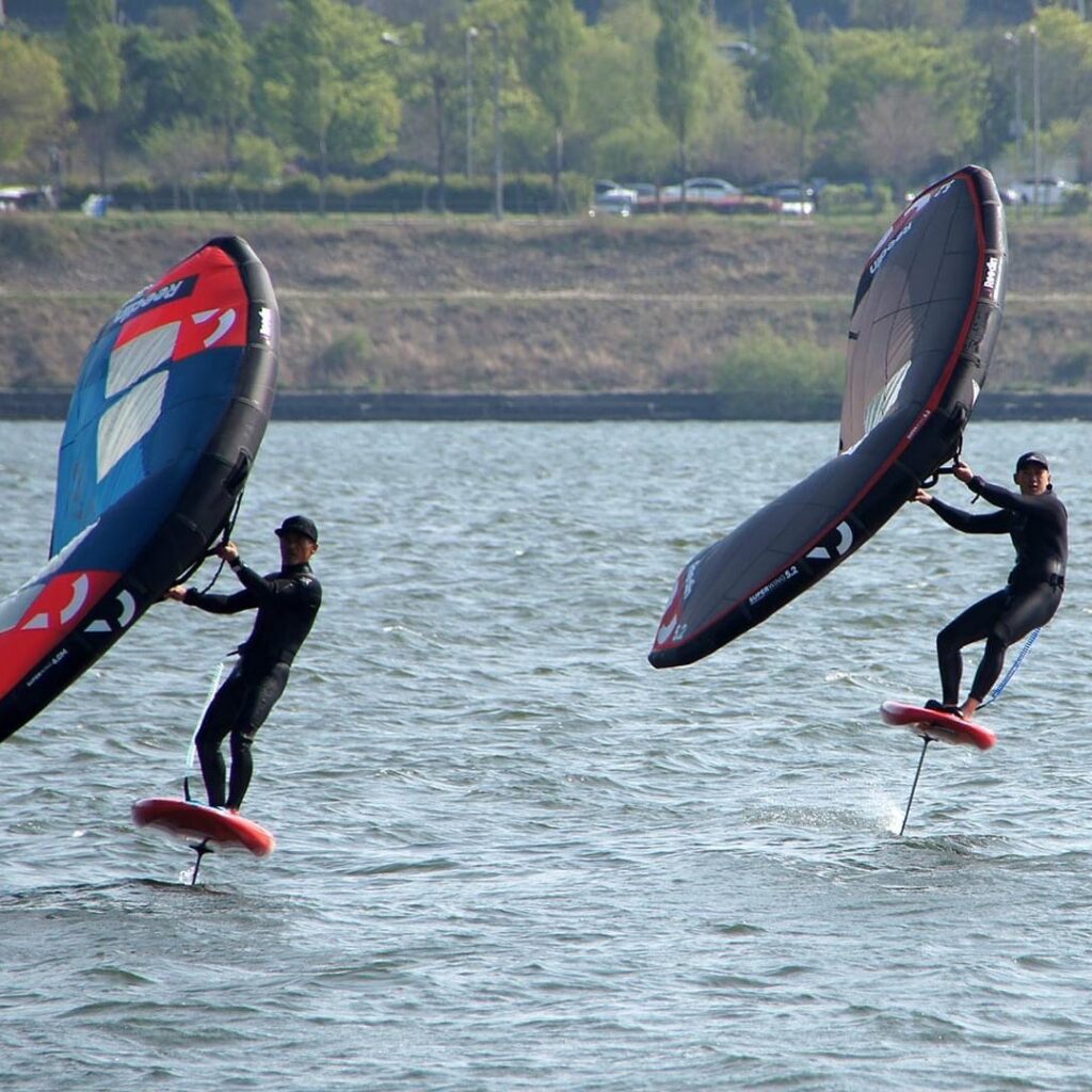 Father and son riding their Reedin wing foil gear on the Han river in Seoul South Korea. Where they wing foil every day even in winter they will enjoy the wind and use it to enjoy a range of water sports on the Hangang.