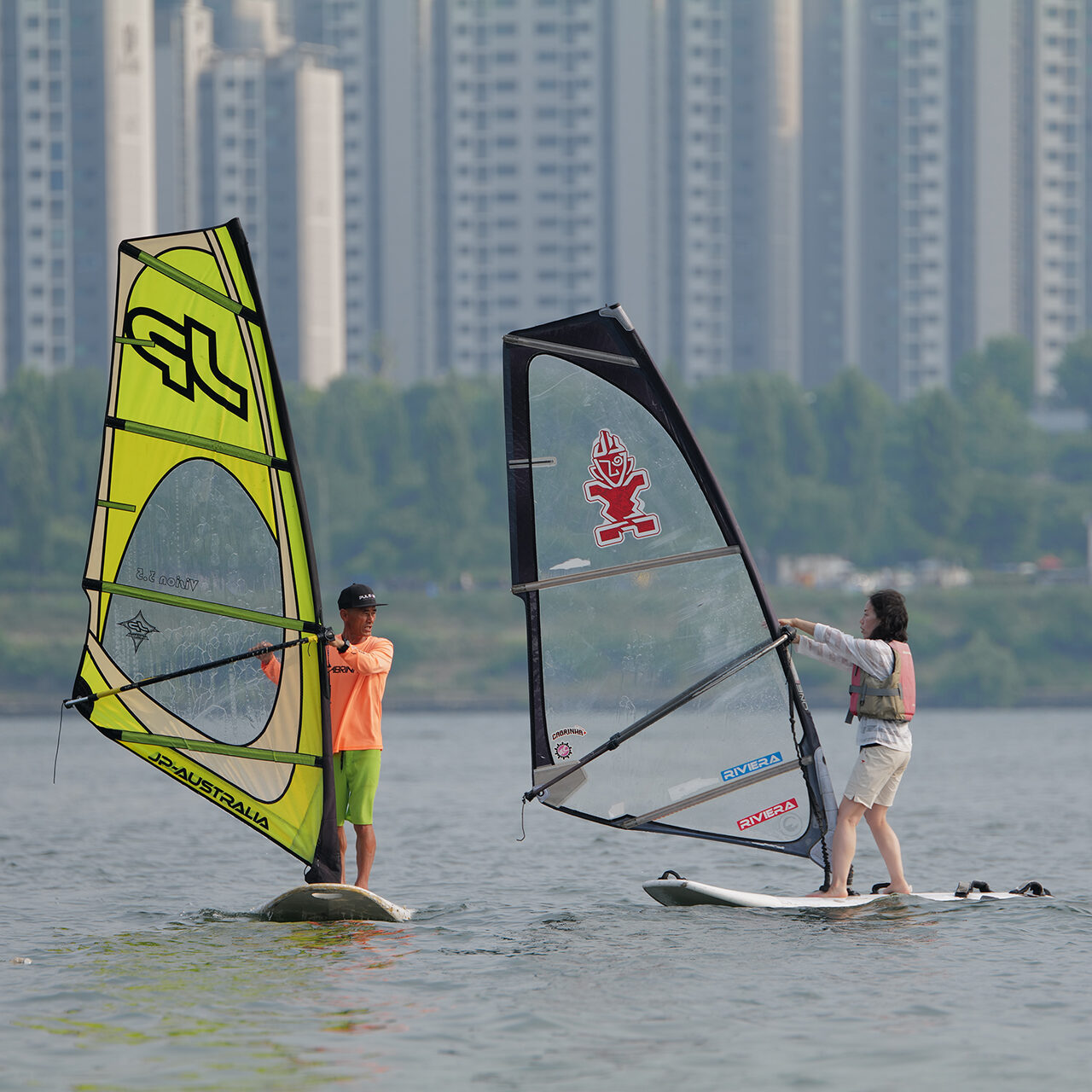 woman getting windsurf lessons at the Han river Seoul. Watersports Seoul. Water leisure Seoul. Hi-Wind wind surf lessons