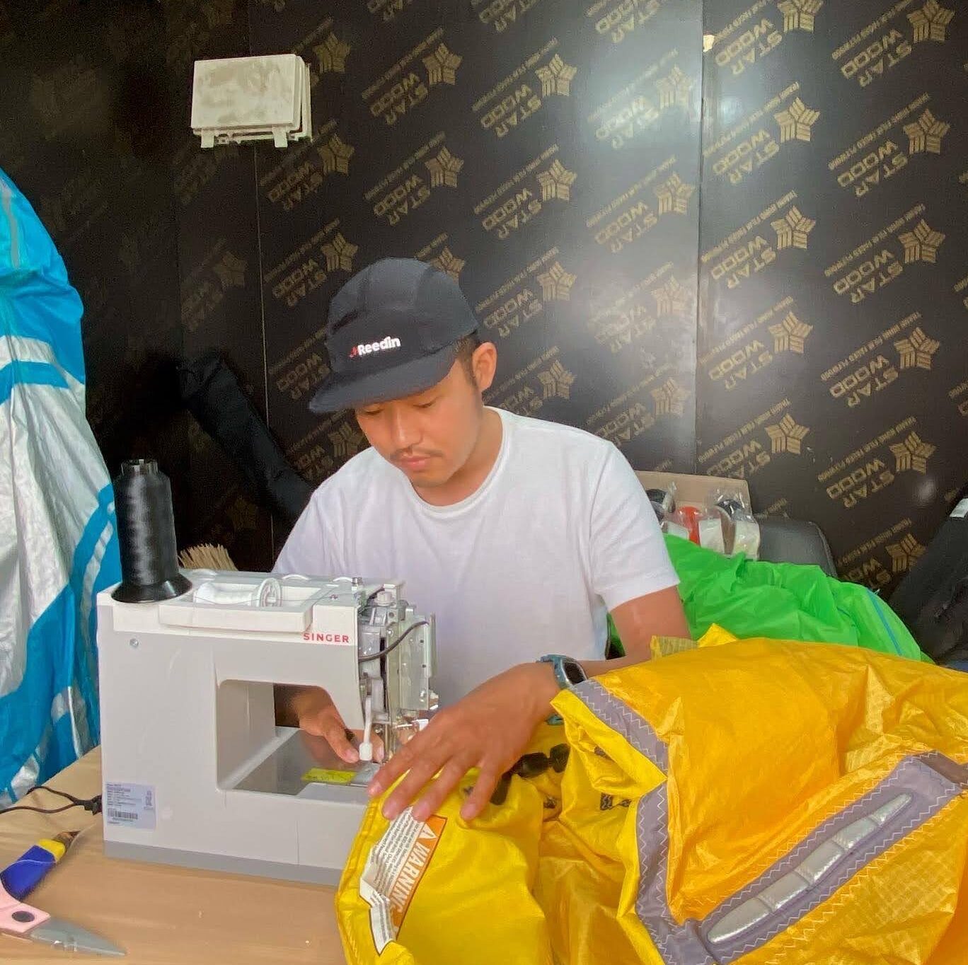 Jeju Kite lab owner professionally repairing broken kites and gear on his sewing machine in Jeju island. Kitesurfing Jeju island South Korea, wing foil Jeju island South Korea