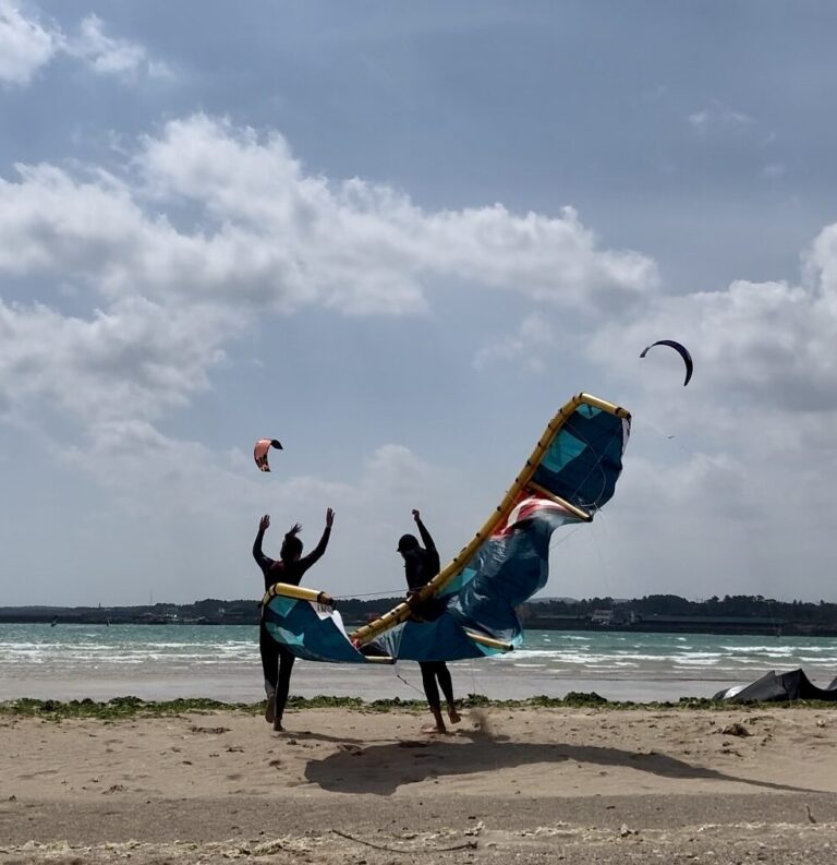 Start of the windy season in Jeju island. Start of the kitesurf season Jeju island, South Korea. Two happy people on the beach with a 7 meter reedin aluula kite.