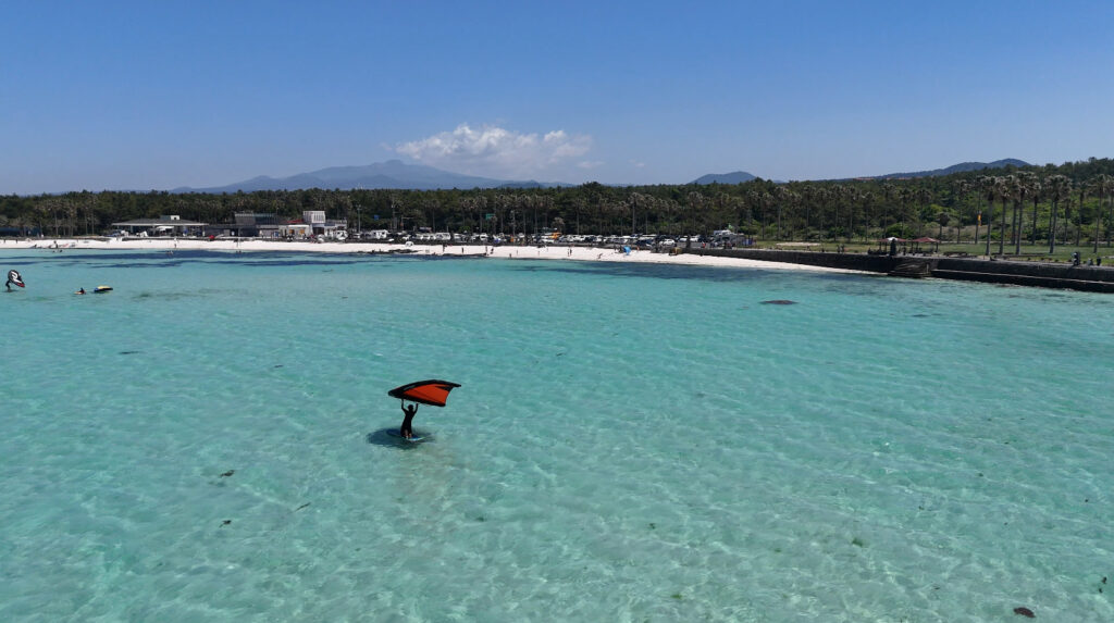 wing foiling west Jeju, South Korea. Wing foiling with Hallasan view, crystal clear blue waters of Jeju island